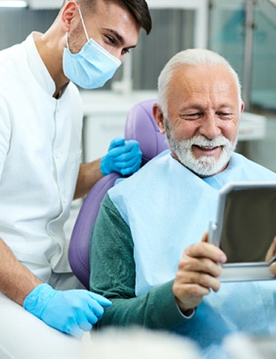 Senior dental patient talking with his dentist