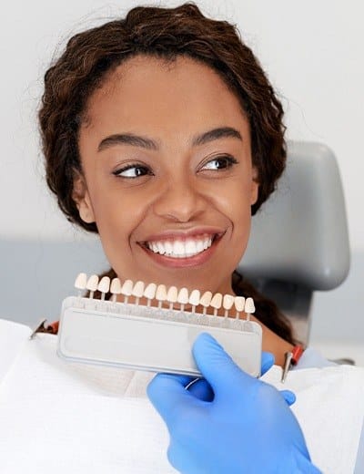 Woman smiling while getting fitted for veneers