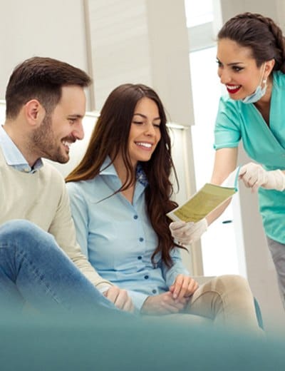 Dentist showing paperwork to smiling couple
