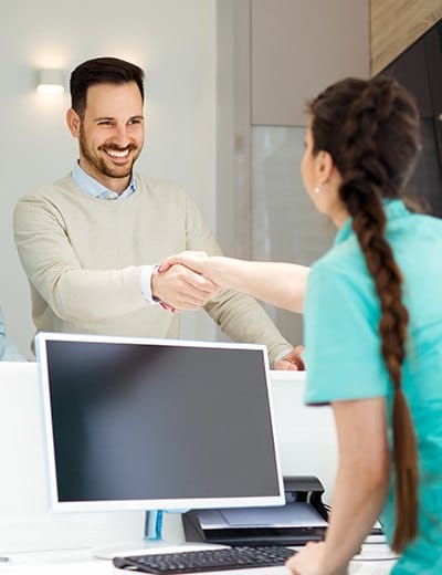 Man checking in at dental office reception desk