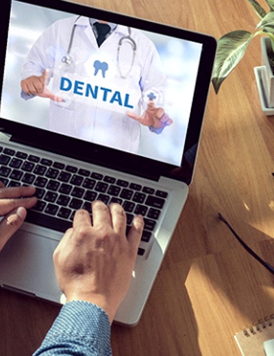 Person using laptop to learn about dental insurance benefits