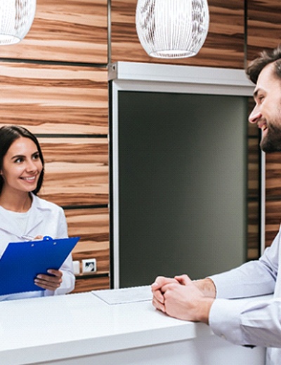 Patient interacting with front office staff in dental practice