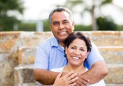 Older couple smiling with dental crowns in North Dallas