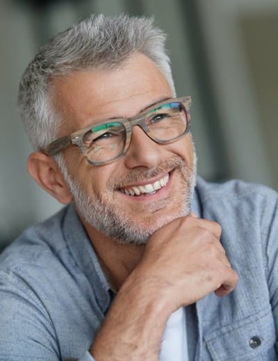 older man wearing glasses and smiling 