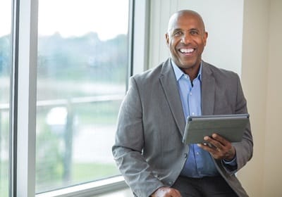 person smiling and looking at a tablet