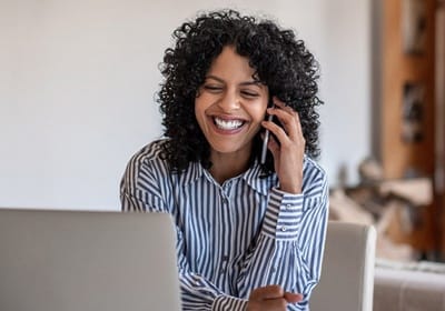 person smiling and talking on the phone