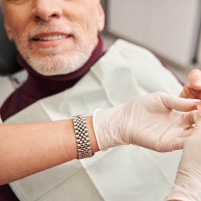Man in dental chair receiving new dentures