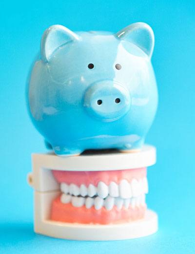 Piggy bank on top of model of dentures