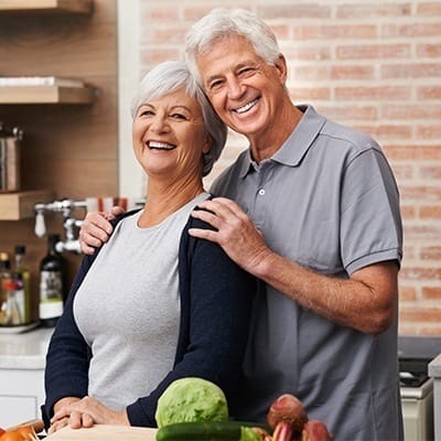 Senior couple smiling in their kitchen