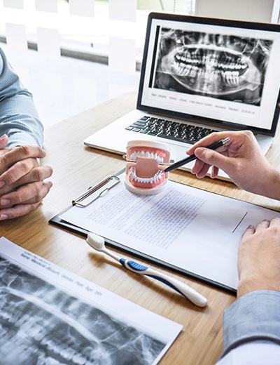 Dentist explaining cost of treating dental emergencies