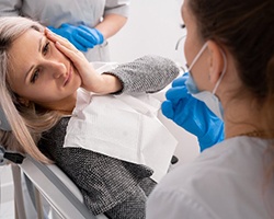 Lady with oral pain looks to dentist