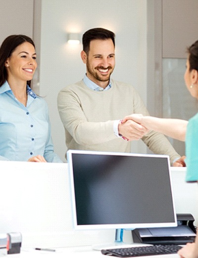 Patient shaking hands with member of dental office staff