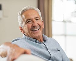 Older man leaning back on couch and smiling