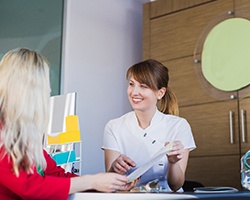 dental team member showing paperwork to a patient