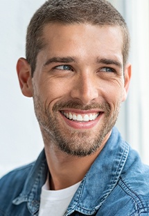 smiling man in denim shirt