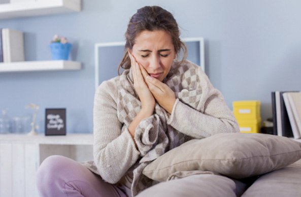 woman holding mouth in pain in Worcester