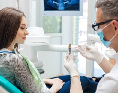 team member showing implant model to patient in Worcester