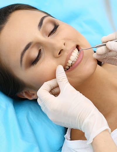 Woman having her teeth and gums examined by dentist