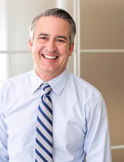 older man wearing tie and smiling