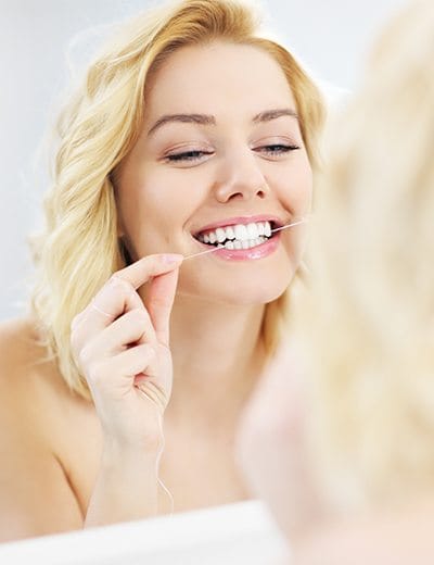 Woman flossing teeth