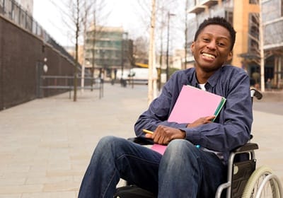 student smiling and holding paperwork