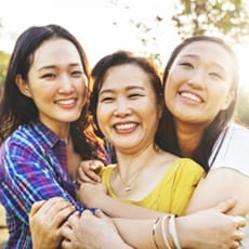 Mother and two daughters smiling after receiving dental services in North Dallas