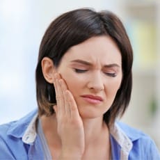 Woman in pain holding her jaw