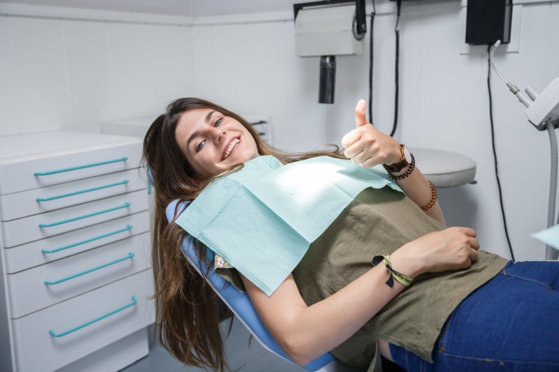 woman safely reclining in chair at dentist in North Dallas