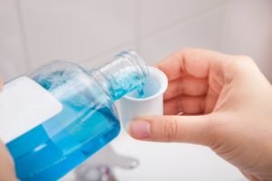 dentist in North Dallas pouring mouthwash into cup 